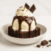Triple chocolate brownie sundae with ice cream, whipped cream, and chocolate sauce