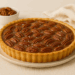 Salted caramel pecan tart with glossy caramel and toasted pecans