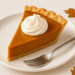 Homemade pumpkin pie slice with whipped cream